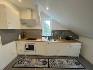 une cuisine avec des armoires blanches et une fenêtre dans l'établissement Übernachtung by Tag, à Staufenberg 12 autres photos