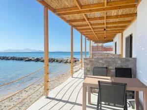 a house on the beach with a table and chairs at aelia beach living II in Kardamaina