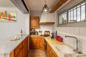a kitchen with wooden cabinets and a sink at Maison spacieuse & calme à 9 min de la Cité in Carcassonne +16 photos