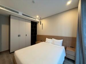 a bedroom with a white bed and a closet at Regal Residences Tay Ho in Kon Rung (1)