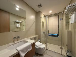 a bathroom with a toilet and a sink and a shower at Regal Residences Tay Ho in Kon Rung (1)