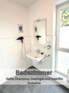 a bathroom with a sink and a mirror at Ferienwohnung "Atlantis" Papenburg Balkon Einbauküche Neubau 74 qm Free Wifi 2 Schlafzimmer 4 Personen in Papenburg +27 photos
