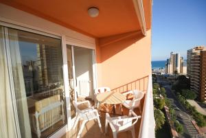 a balcony with a table and chairs and a view of the city at Apartamentos Concorde in Alicante