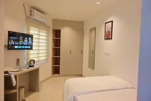a hospital room with a bed and a television at Saba's Courtyard in Kolachel