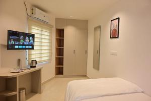 a bedroom with a bed and a tv on the wall at Saba's Courtyard in Kolachel
