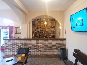 默主歌耶Hotel Holy Miracle的餐厅内的酒吧,墙上配有电视