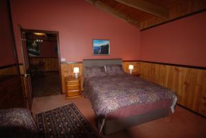 a bedroom with a large bed in a room with red walls at Wrenwood Chalets in Augusta