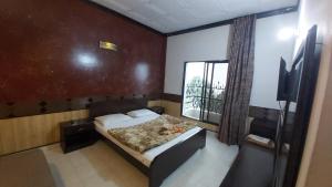 a small bedroom with a bed and a window at Mount Heaven Hotel Murree in Murree