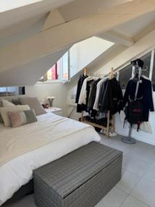 Un dormitorio con una cama grande y ropa en percheros. en Joli T2 au coeur de Biarritz, en Biarritz