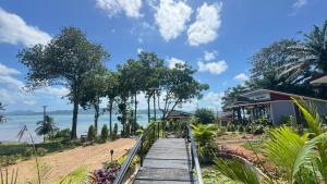 a wooden pathway leading to a beach with a house at Relax sunsmile Kohyaonoi in Ko Yao Noi