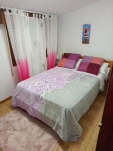 a bedroom with a bed with pink and purple sheets at B&B Santiago de Redecilla del camino in Redecilla del Camino +6 photos