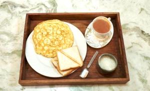 a plate of food with pancakes and a cup of coffee at Greenoriva Aero Srinagar in Srinagar