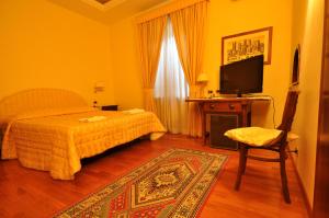 a bedroom with a bed and a tv and a chair at Casale De Santis in Rome +35 photos