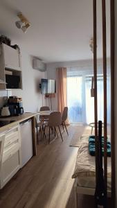 una cucina e un soggiorno con tavolo e sedie di Studio by the River with Terrace, Basen, Sauna, Jacuzzi, Fitness a Dziwnów