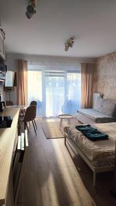 un soggiorno con un divano e un tavolo di Studio by the River with Terrace, Basen, Sauna, Jacuzzi, Fitness a Dziwnów