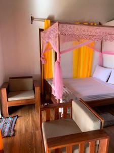 a bedroom with two bunk beds with a canopy at Chambre pour 4 personnes in Ambodiatafana