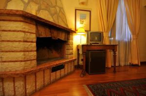 a living room with a stone fireplace and a television at Casale De Santis in Rome
