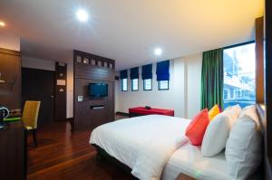 Nicha Suite Hua Hin Hotel في هوا هين: غرفه فندقيه سرير وتلفزيون