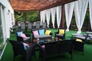 a patio with chairs and tables on a green floor at Ferienwohnungen TalBach in Simmerath