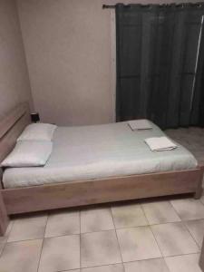 a bed with a wooden frame in a room at House, lot, secure private parking in Issoudun