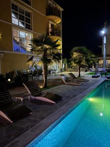 a pool with lounge chairs next to a building at night at Vila Kristina in Negotin