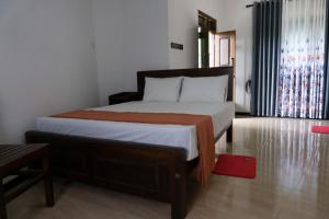 a bedroom with a bed and a red rug at Rasal Homestay in Ella