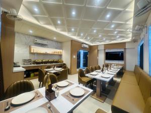 a restaurant with tables and chairs in a room at hotel deep palace in Varanasi