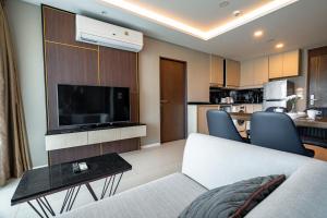 un salon avec un canapé et une télévision dans l'établissement Two Bedrooms Seaview Apartment Surin Bangtao Area 4407, à Ban Lum Fuang