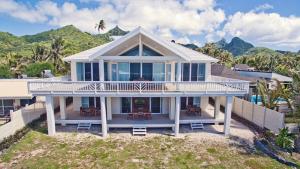 Seaside Beachfront Villas Rarotonga في راروتونغا: منزل على الشاطئ مع جبال في الخلفية