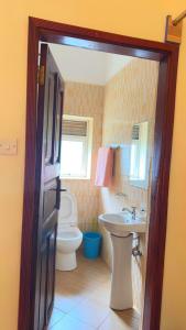 a bathroom with a toilet and a sink at Karibu motel mbale in Mbale