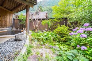 a garden area with a bench and some plants at Kazeya in Takayama