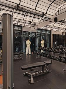 Dos personas de pie en un gimnasio con máquinas. en Scarletz Suites by Moon-Moon, en Kuala Lumpur