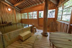 a room with a wooden floor and a large tub at Kazeya in Takayama