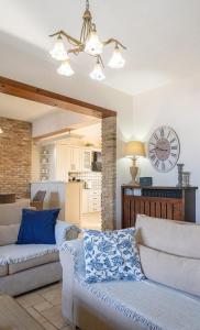 a living room with a couch and a clock on the wall at Han’s Maisonette in Porto Heli +42 photos