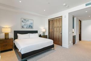 a bedroom with a white bed and a wooden door at Argent at Deer Valley Resort - Hotel Room #105B Hotel Room in Park City