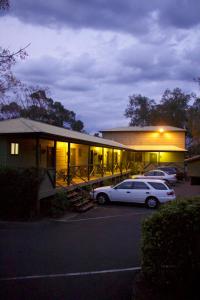 un coche blanco estacionado frente a un edificio en Lake Forbes Motel, en Forbes