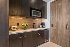 a kitchen with wooden cabinets and a sink and a microwave at Argent at Deer Valley Resort - Hotel Room #105A Hotel Room in Park City