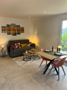 a living room with a couch and a table at Studio Shangri-LA - Entrée & terrasse privatives - Vue mer - Parking in Menton +43 photos