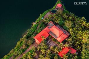 an island with a red house on top of it at EKOSTAY - Escobar Villa 8 BHK in Pune