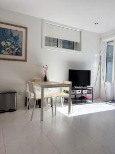 a living room with a table and chairs and a tv at Fancy Family Suite with Parking near UBC in Vancouver