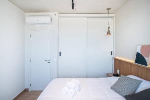 a bedroom with a white bed with two sliding doors at Dark - Hassler - 105 - Jose Canese in Asuncion