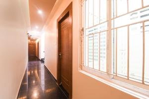 a hallway with a large window in a building at Collection O Paschim Dwar Near Jagannath Temple Formerly Hotel Subhadarshan in Puri +42 photos