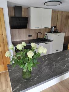 a kitchen with a vase of flowers on a counter at Ferienwohnung Kofler in Aurach am Hongar +9 photos