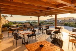 Un restaurante con mesas y sillas en un patio. en Aelo Mykonos Hotel, en Paradise Beach