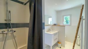 a bathroom with a sink and a shower with a shower curtain at Jolie maison rénovée sur Loix in Loix +7 photos