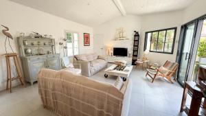 a living room with a couch and a table at Jolie maison rénovée sur Loix in Loix