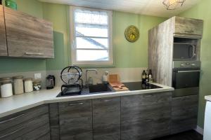a kitchen with wooden cabinets and a sink and a window at Very bright nest with terrace in the village in La Flotte