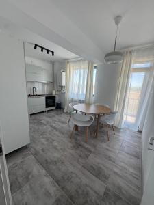 a kitchen and dining room with a table and chairs at Daly Residence in Buzau