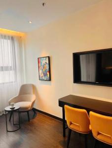 a living room with a flat screen tv and chairs at Homestay Sapphire S2 cho thuê theo giờ 2 tiếng in Ha Long