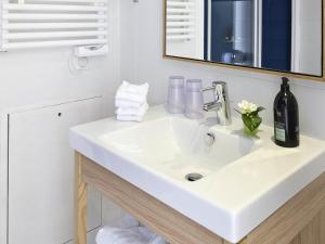 La salle de bains est pourvue d'un lavabo blanc et d'une bouteille de vin. dans l'établissement Aparthotel Adagio Paris Vincennes, à Vincennes 36 autres photos